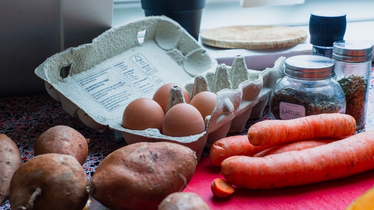eggs in tray beside carrots