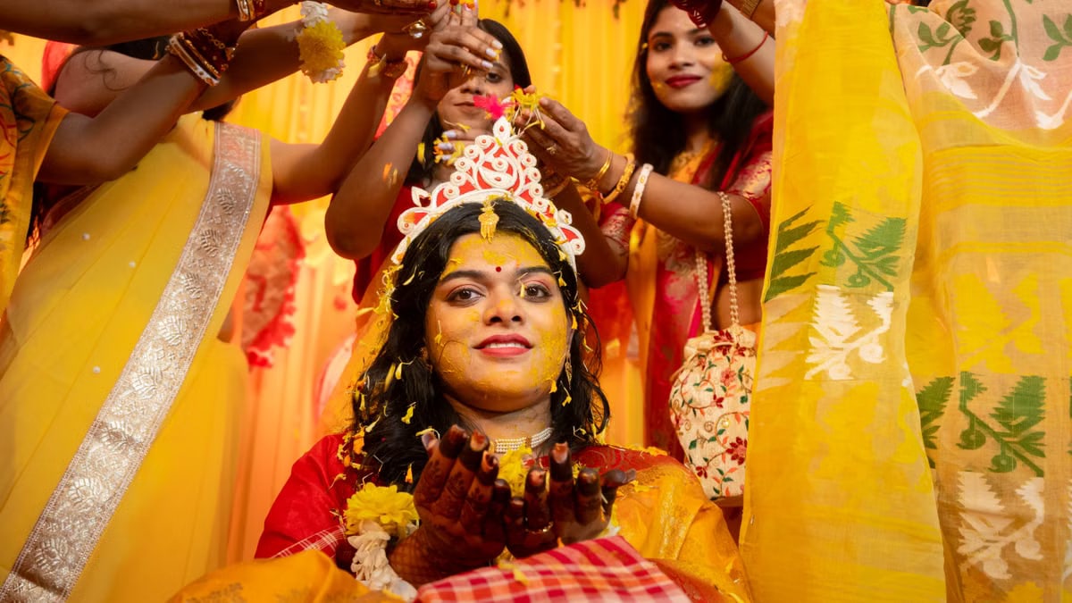 A vibrant and colorful Indian bride participating in a traditional wedding ceremony with friends and family.