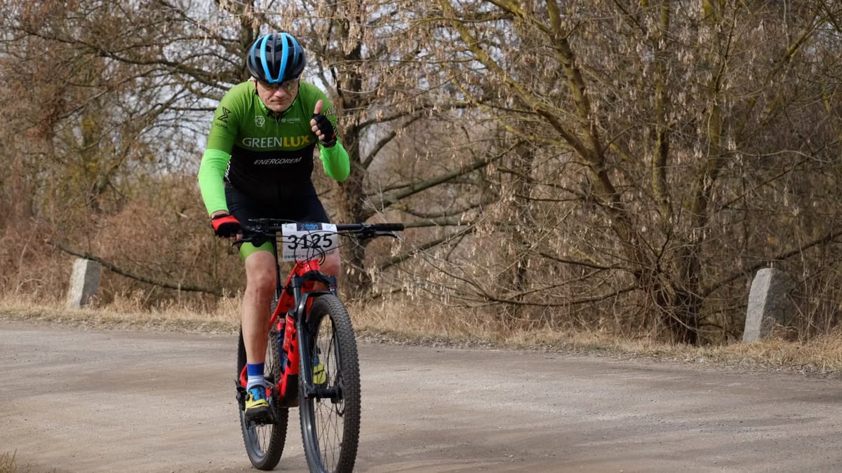 Senior athlete participates in mountain bike race on a rural path, showcasing endurance and determination.